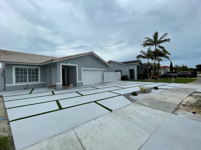 Custom concrete driveway with turf accents in Doral FL