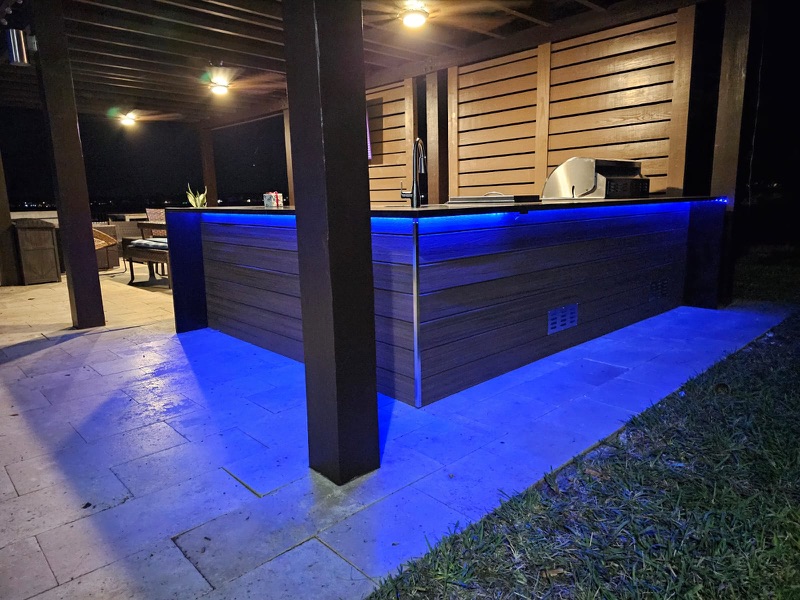 Outdoor kitchen with built-in grill and bar seating in South Florida