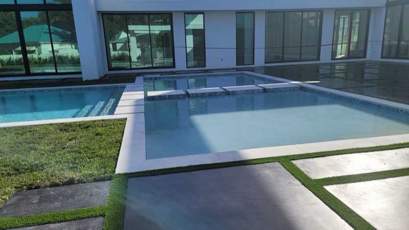 Custom concrete patio with turf accents in Miami-Dade FL